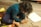 Close-up of a child drawing with crayons on a wooden table.
