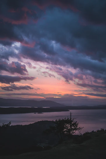 View from the Hilltop Suite balcony showing Lake Travis under a glowing sunset.