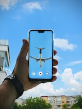 Close-up of hands holding a smartphone showing flight options