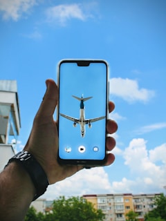 A close-up of a hand holding a smartphone displaying the vueladirecto flight search engine.