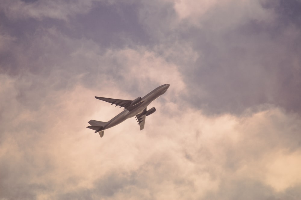 white airplane flying in the sky during daytime