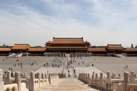 A Spanish-speaking tourist guided through a historic Chinese palace with ancient architecture.