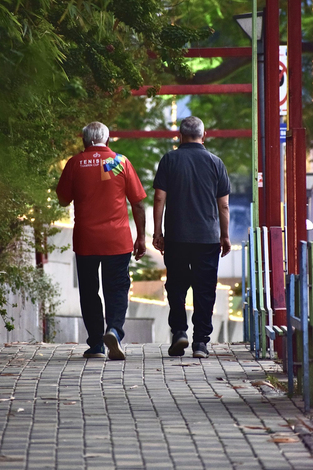 man in red crew neck t-shirt standing beside man in black crew neck t-shirt