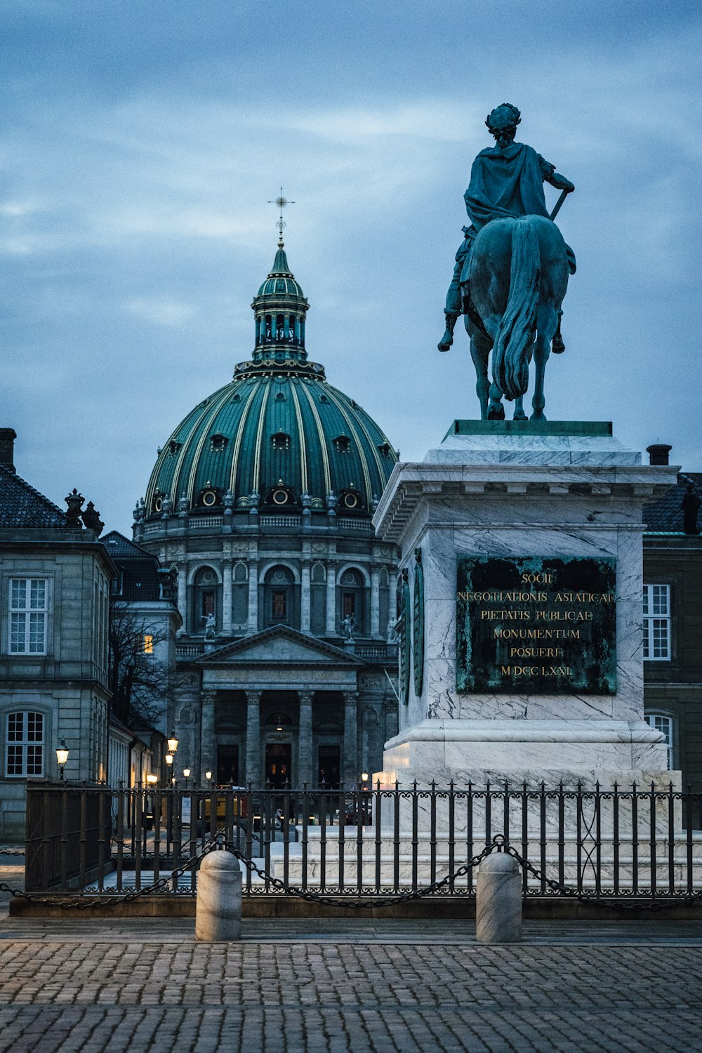 black statue of man riding horse near white concrete building during daytime