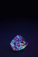purple and green gemstone on black textile