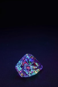 Close-up of a peridot gem reflecting light with a subtle ruby heart glowing at its center.