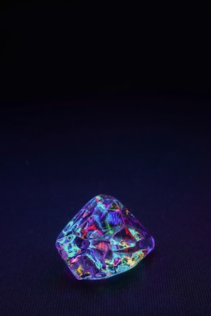 purple and green gemstone on black textile