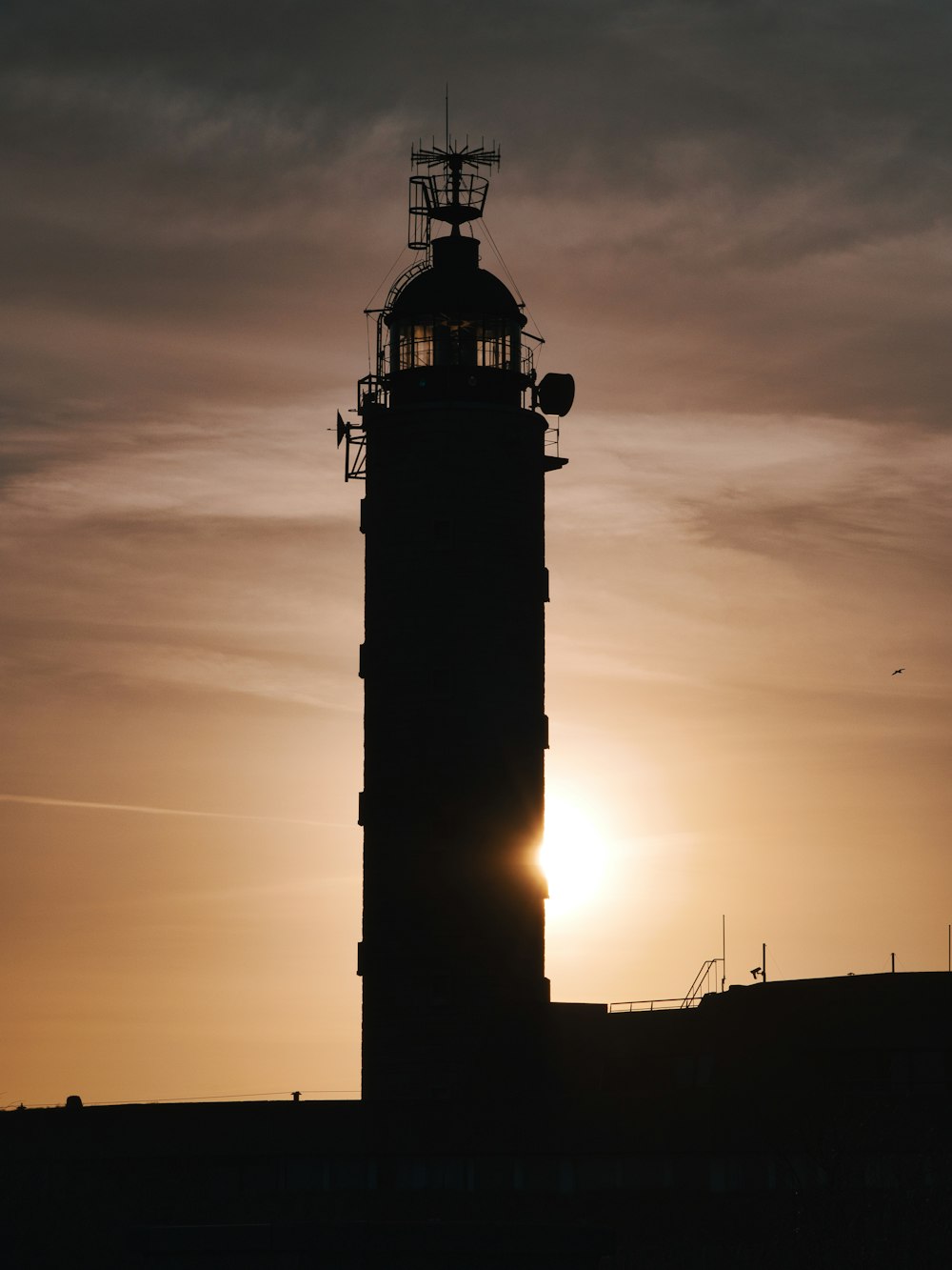 silhouette of a lighthouse during sunset
