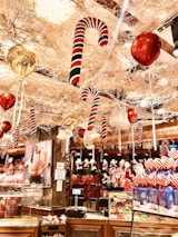 Friendly store staff arranging festive balloons and party favors on shelves.