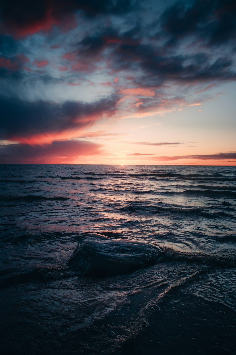 sea waves crashing on shore during sunset