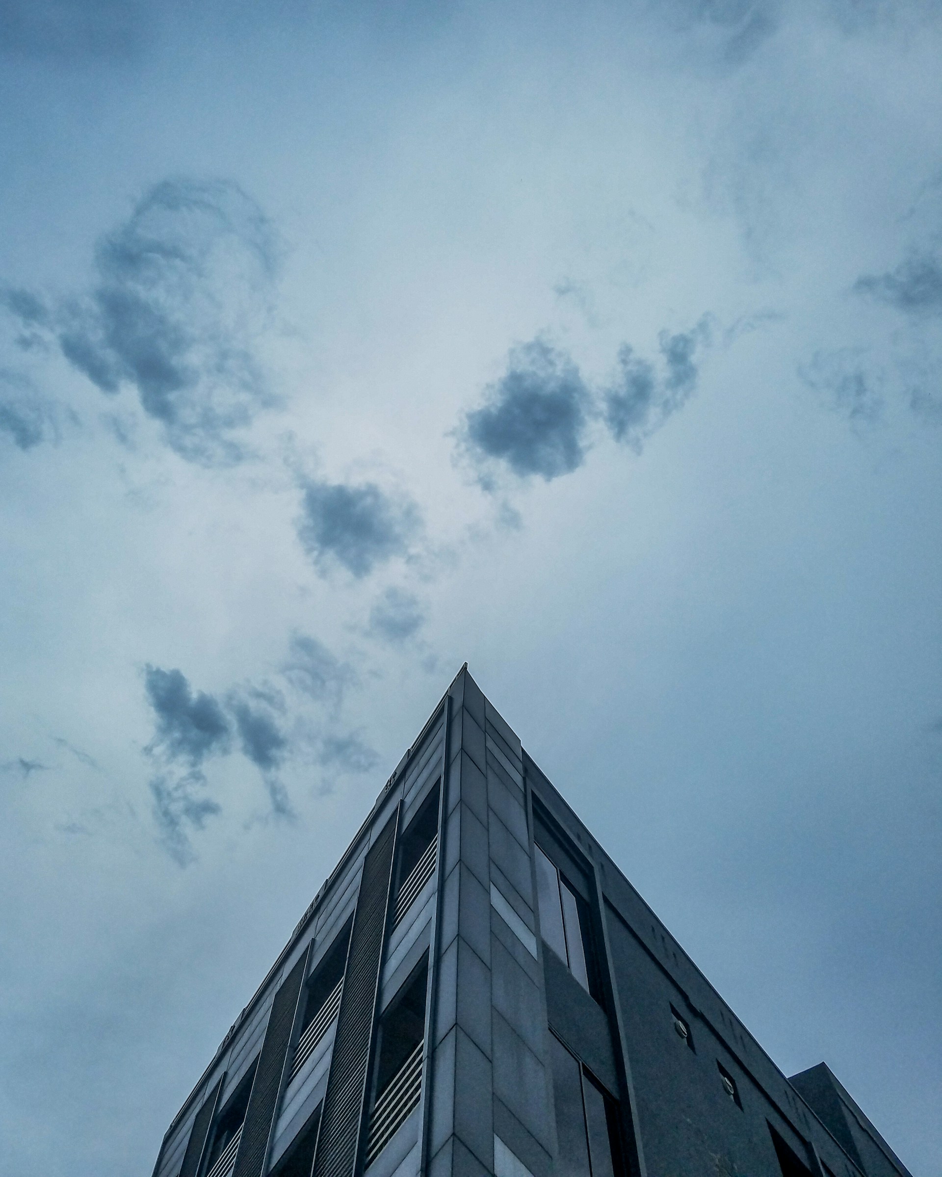 grayscale photo of concrete building under cloudy sky