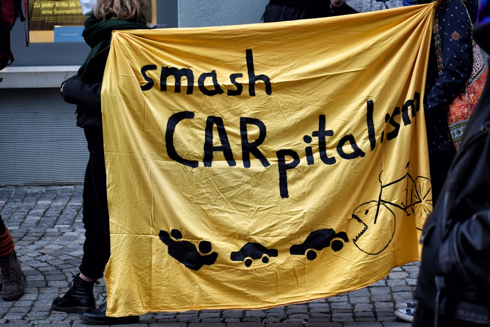 a group of people standing around a yellow sign