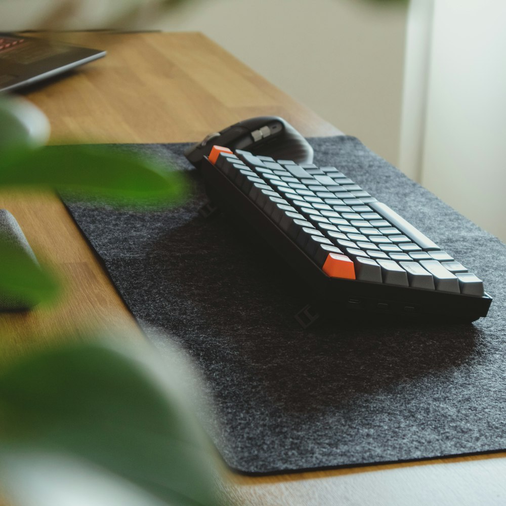 teclado de computador preto e branco na mesa preta