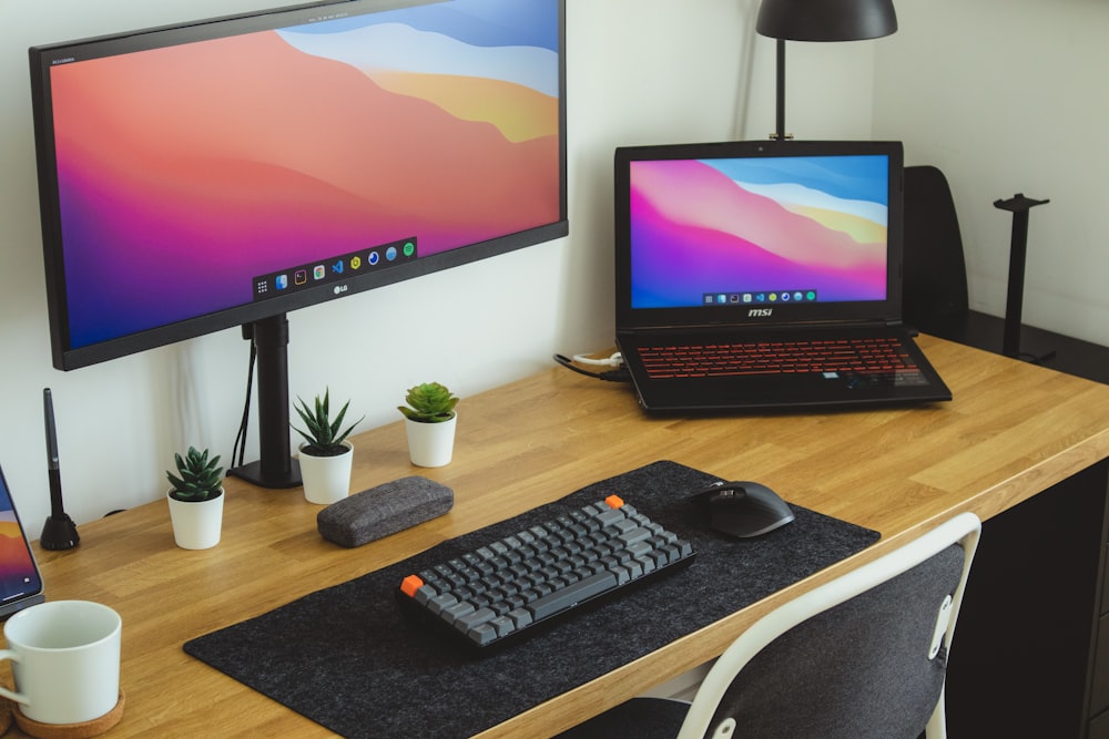 black flat screen computer monitor and black computer keyboard on brown wooden table