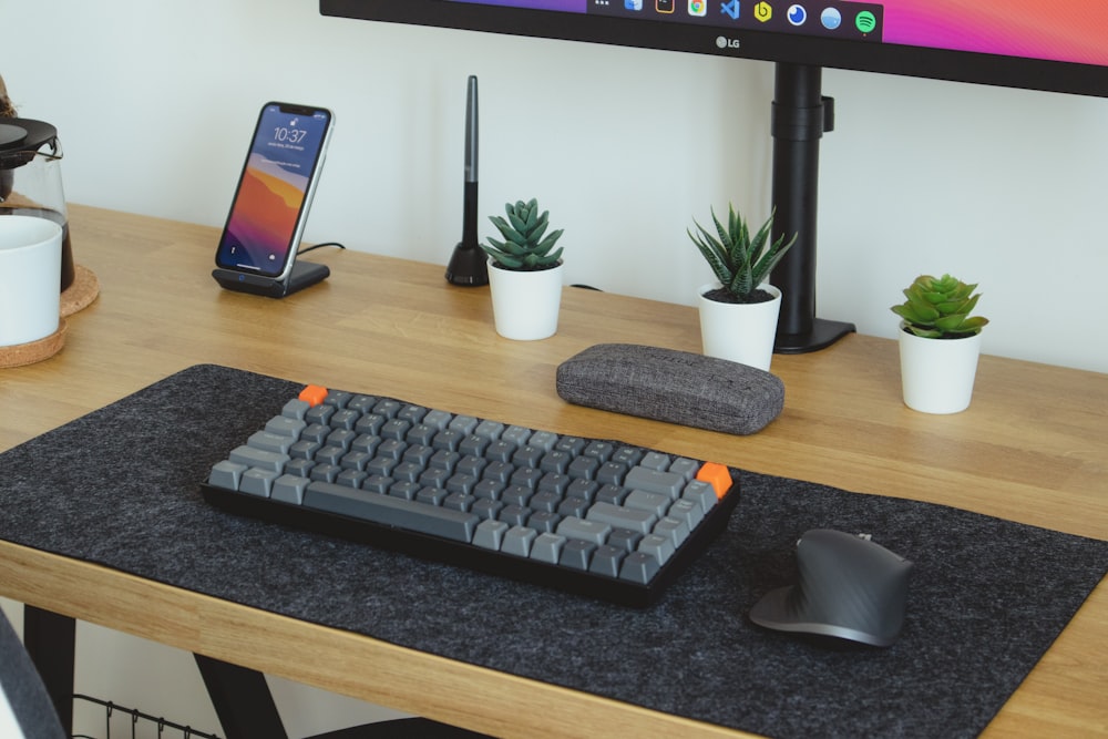 clavier d’ordinateur noir sur table en bois marron