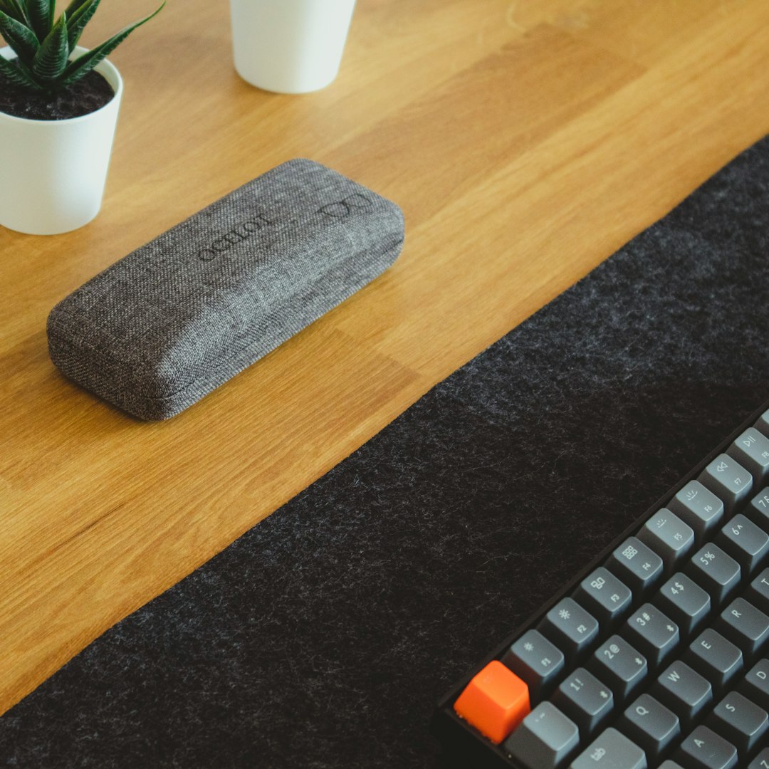 gray and orange computer keyboard on brown wooden table