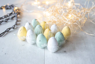 A row of colorful eggs nestled in straw inside a cozy chicken coop.