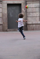 Close-up of a smiling child kicking a soccer ball inside the arena's modern facility.