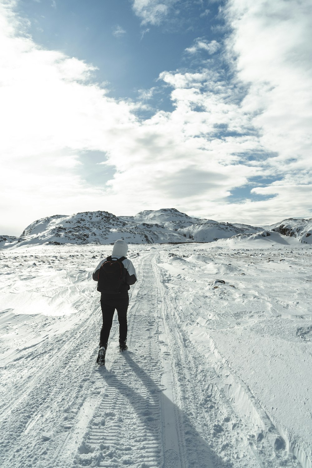 person in black jacket standing on snow covered ground during daytime