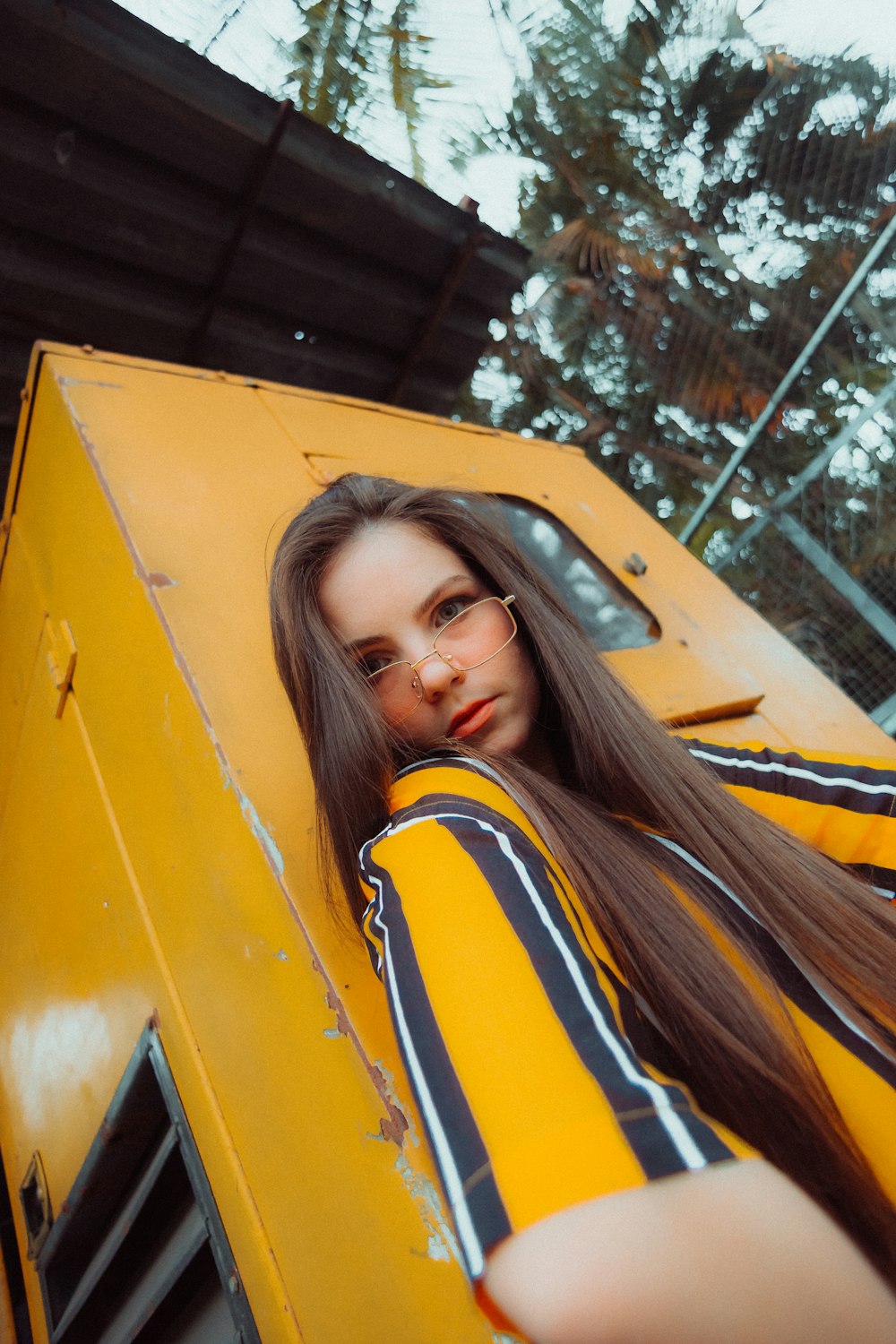 woman in yellow and blue shirt on yellow car