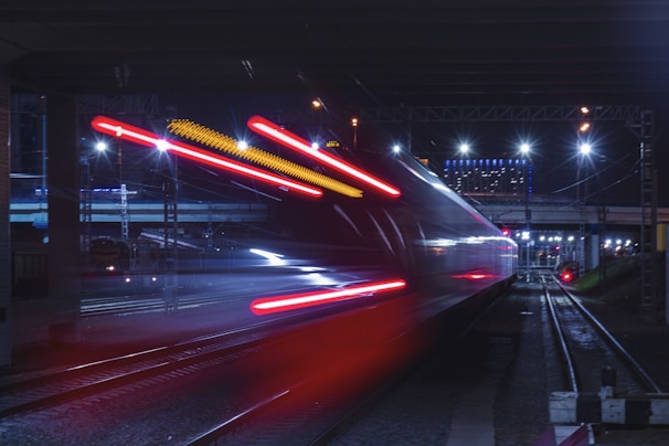 Nighttime shot of the bullet train illuminated as it speeds past city lights.