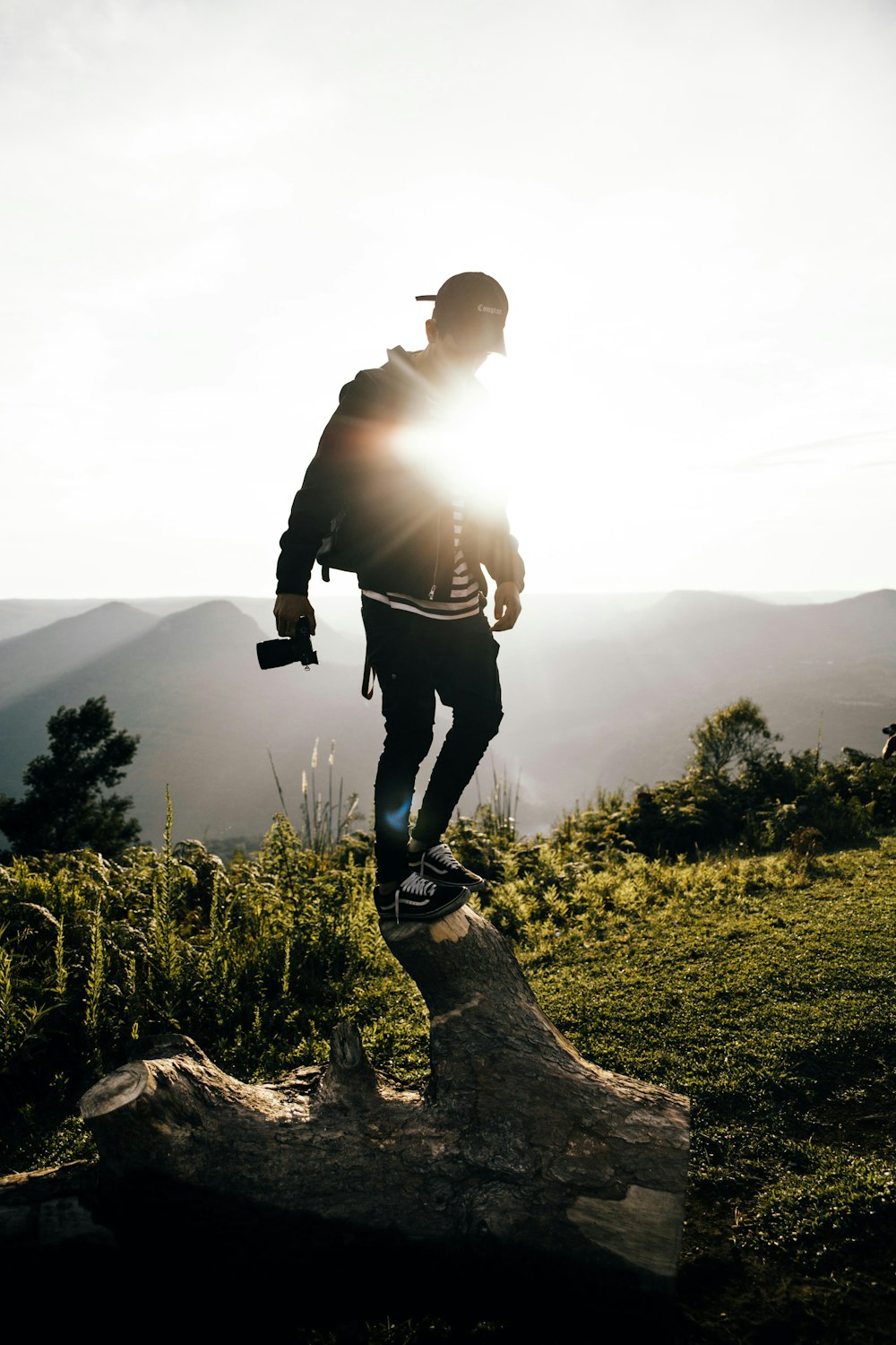 man in black jacket and black pants standing on brown rock during daytime