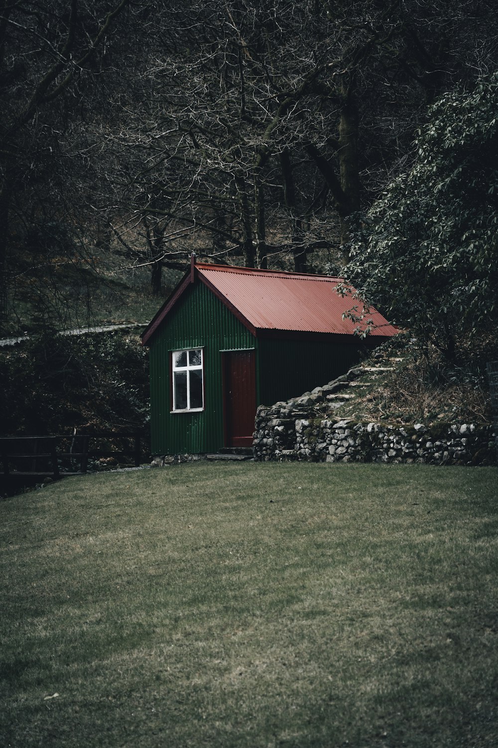 red and white wooden house near green trees during daytime