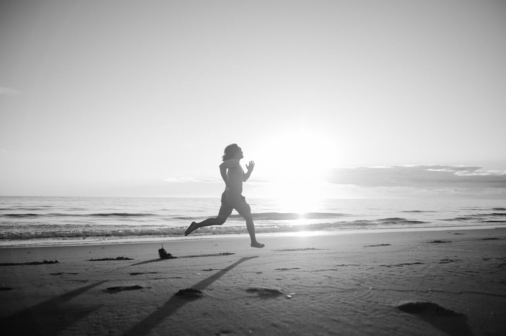 silhouette of woman walking on beach during daytime