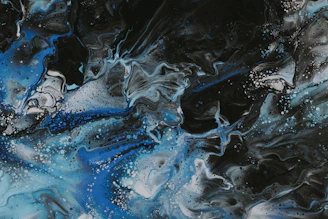 Abstract waves of deep blue and black blending into a misty horizon.