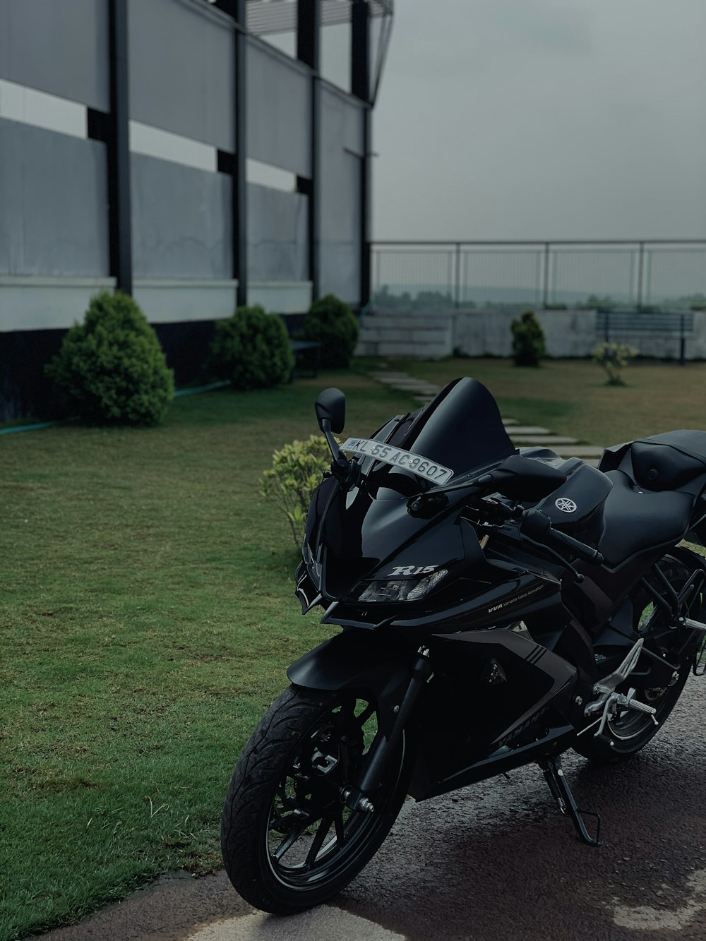 black sports bike parked on green grass field during daytime