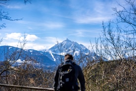 A traveler enjoying a scenic mountain view with a backpack