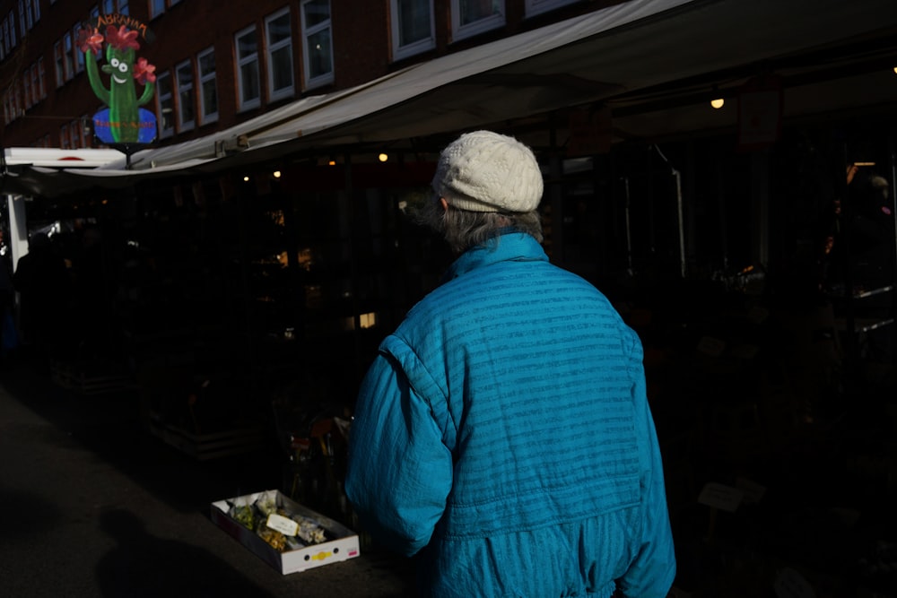 man in blue dress shirt wearing white cap