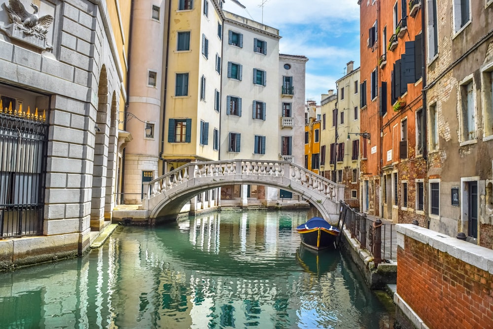 edificio in cemento bianco e marrone accanto al fiume durante il giorno