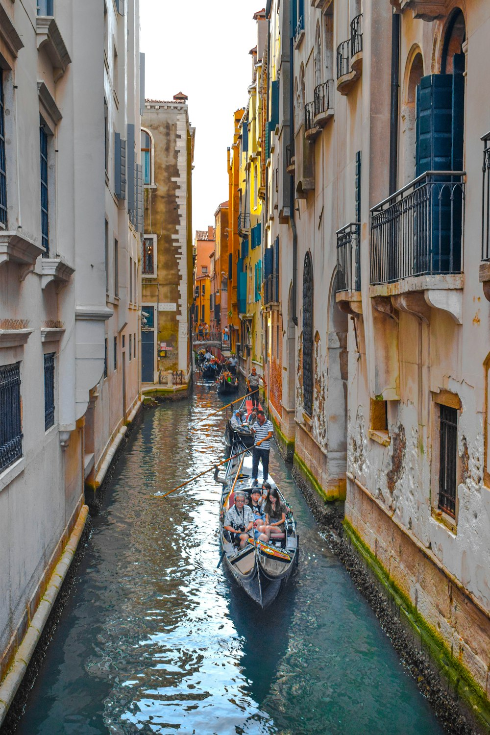 boat on river between buildings during daytime