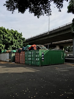 Stacks of shipping containers in soft beige and sage green tones at the warehouse yard