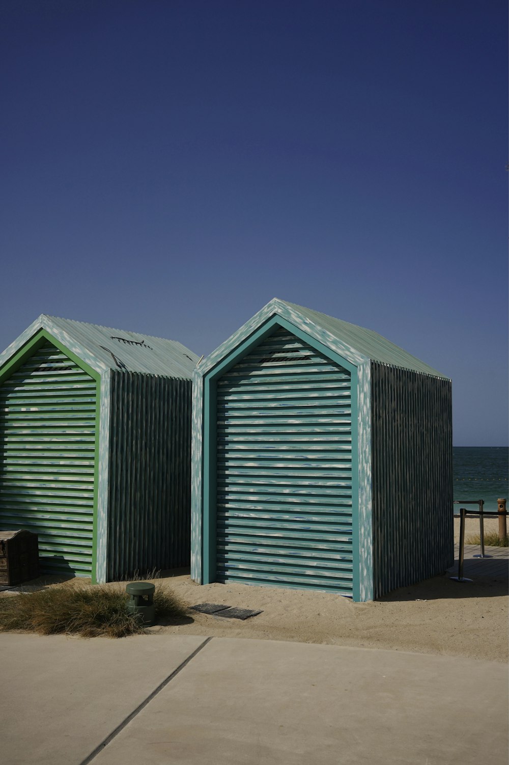 昼間の茶色の砂浜に青い木造住宅