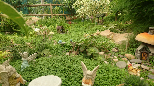 An intricate doll landscaping scene featuring tiny trees, flowers, and a winding path.