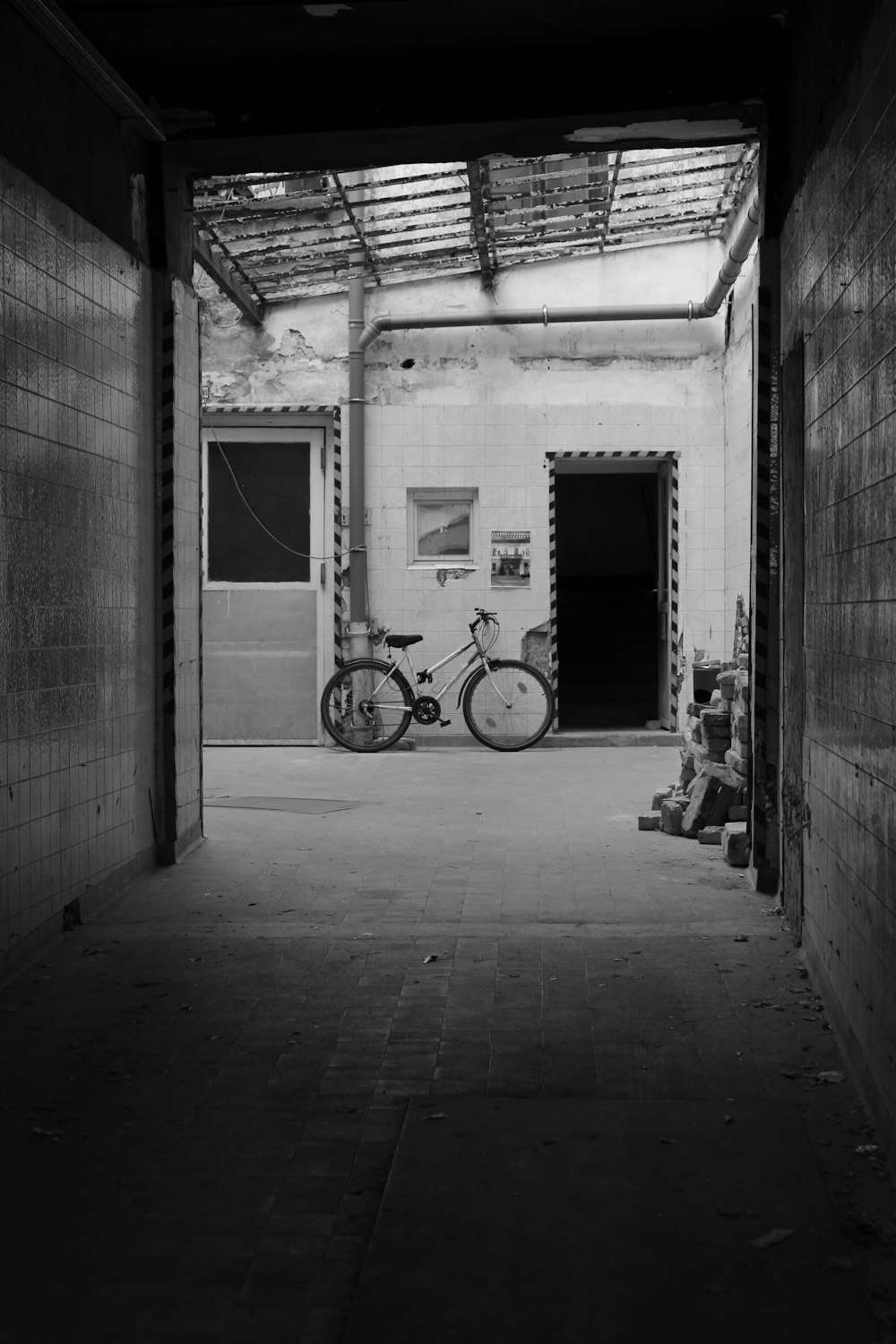 grayscale photo of bicycle in front of door