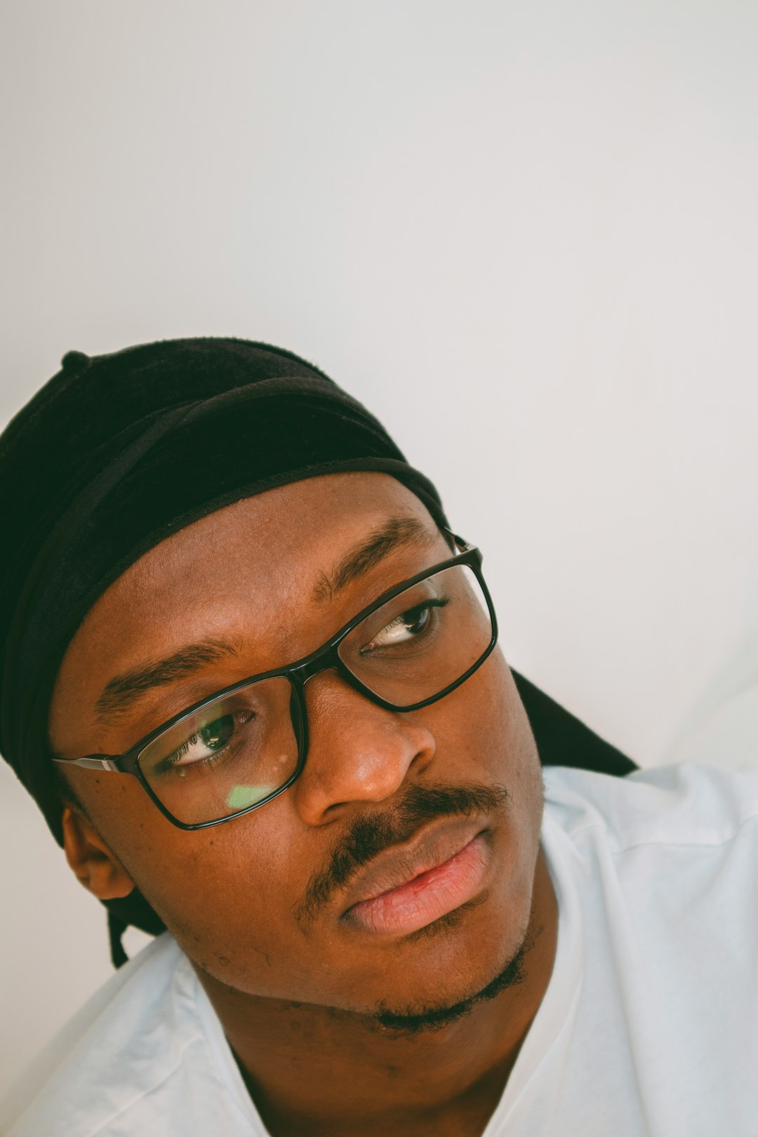 man in white shirt wearing black framed eyeglasses