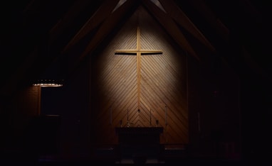 brown wooden cross on brown wooden wall