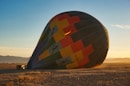 red and blue hot air balloon on brown field during daytime