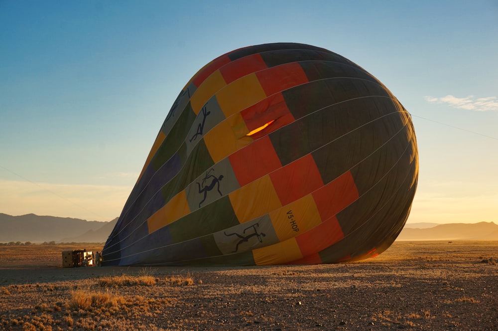 red and blue hot air balloon on brown field during daytime