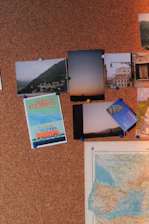 Close-up of a colorful itinerary pinned on a corkboard with photos and notes.