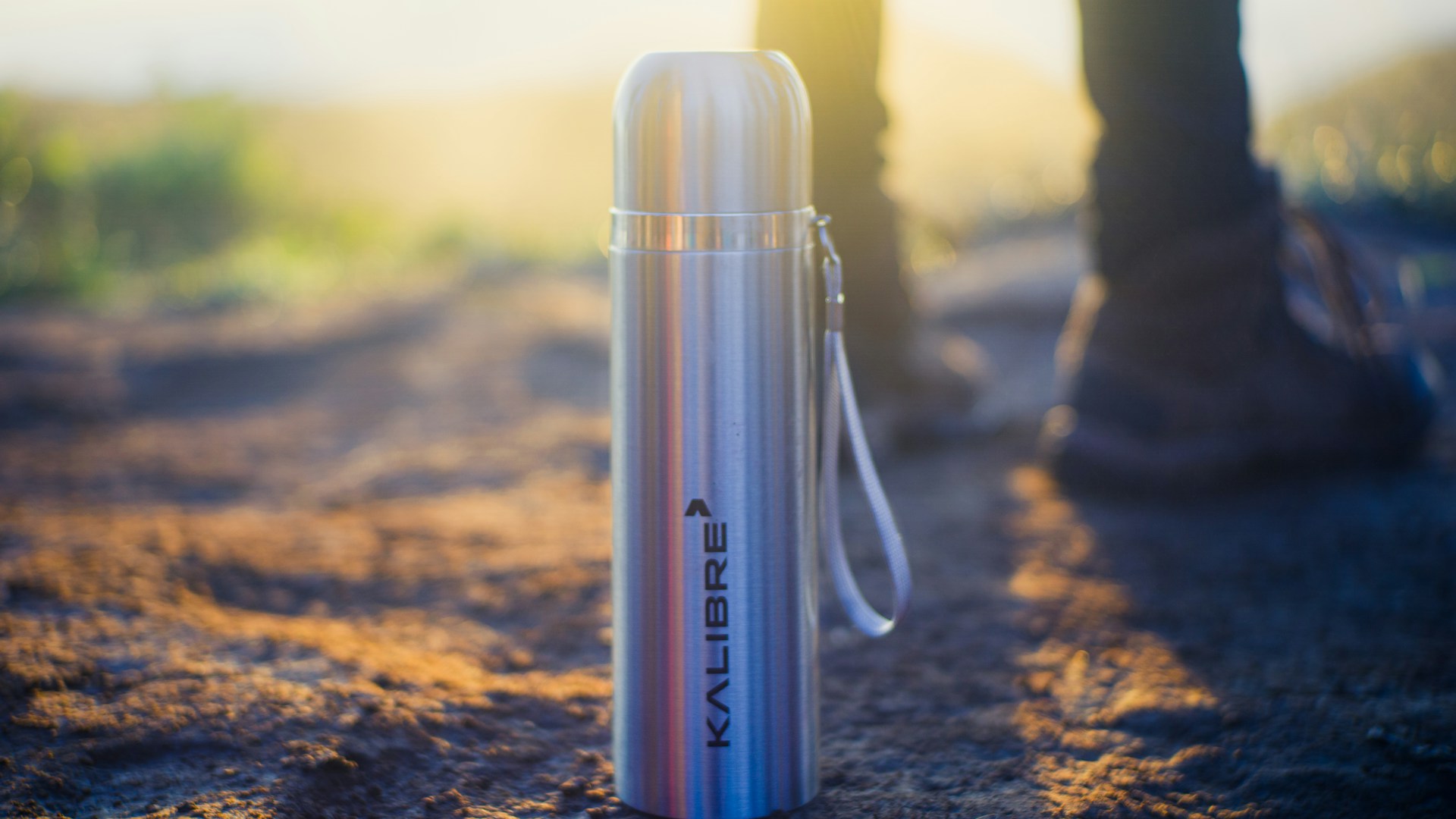 A modern stainless steel thermos standing upright against a bright white backdrop, showcasing its polished finish.