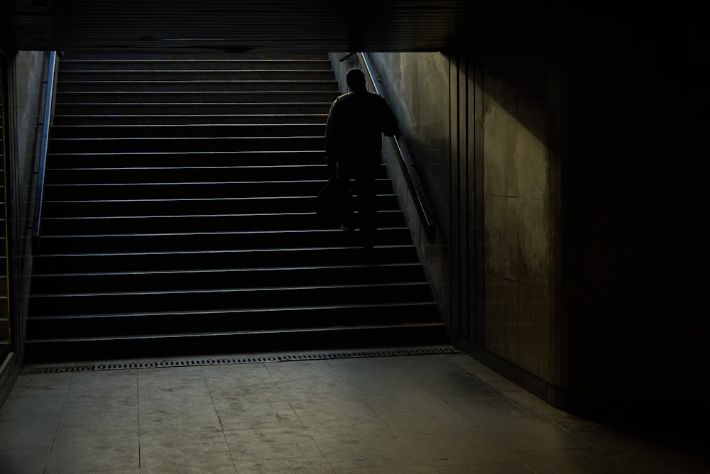 Mann in schwarzer Jacke geht auf der Treppe