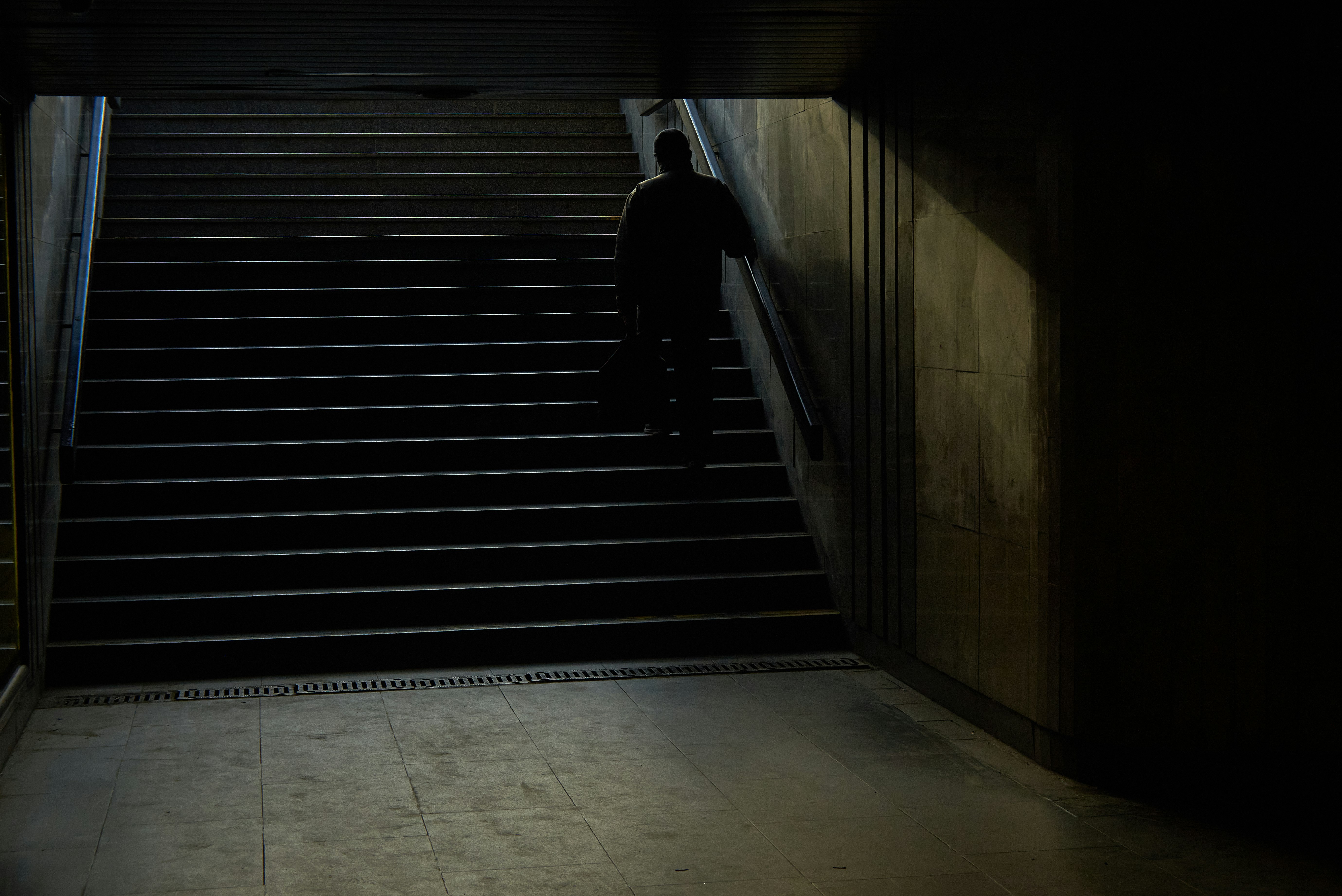 man in black jacket walking on the stairs