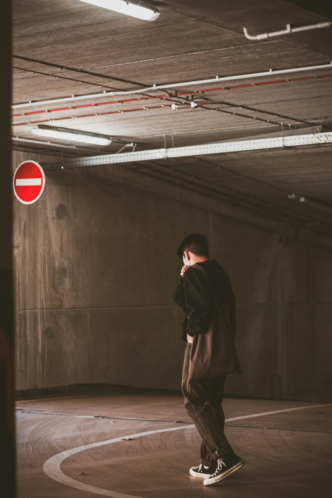 man in black jacket standing on brown wooden floor