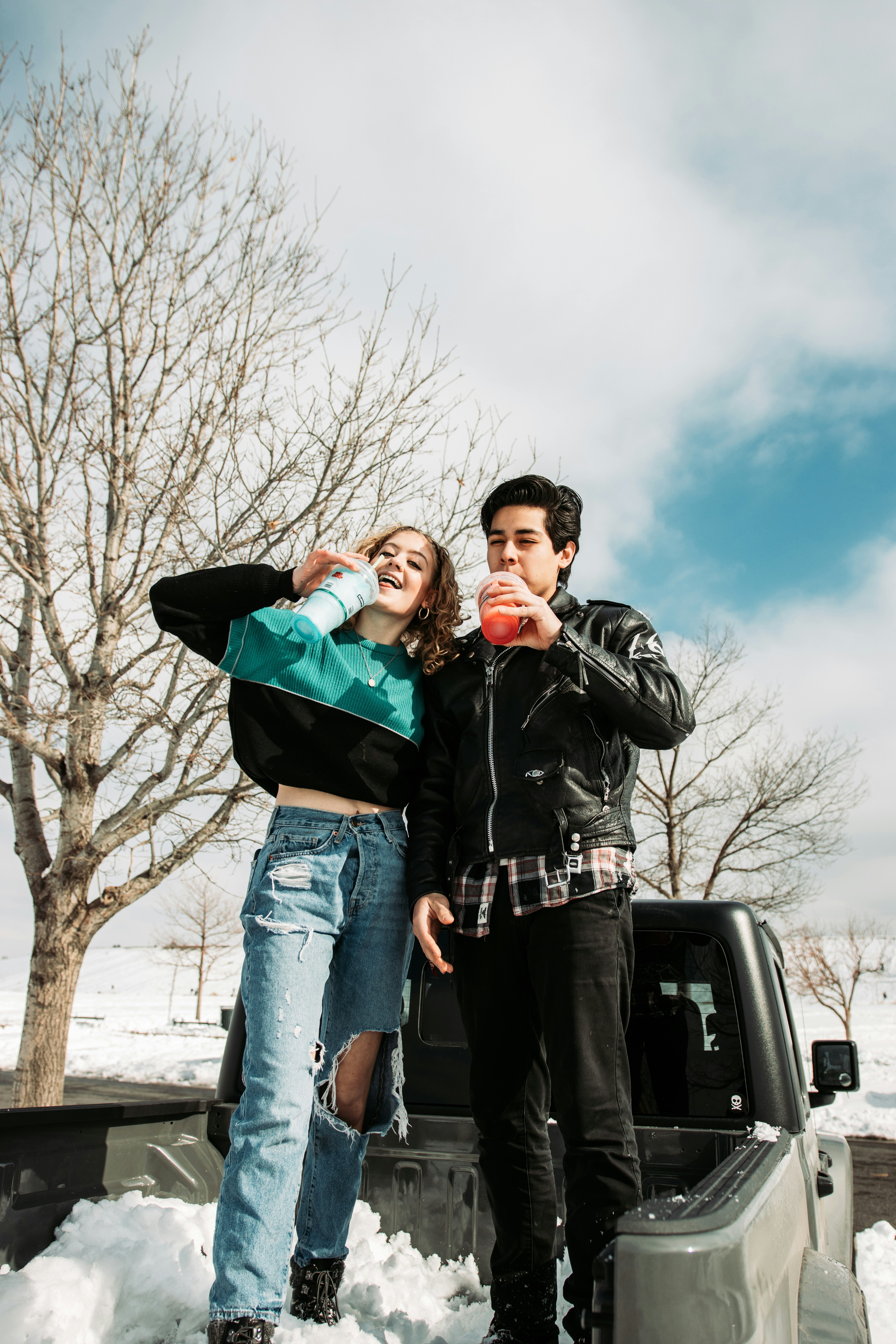 man and woman standing beside black suv during daytime