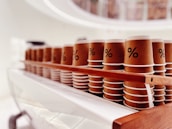 Eco-friendly cups made from coconut shells arranged neatly on a wooden table.