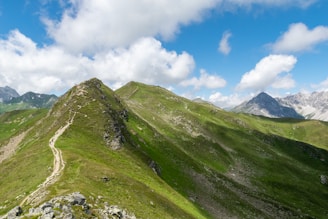 A vibrant photo of a winding mountain trail under a bright blue sky inviting adventure.
